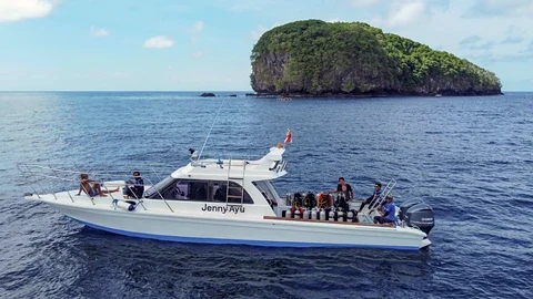 Gäste und aufgereihte Tauchflaschen auf dem Deck der Jenny Ayu