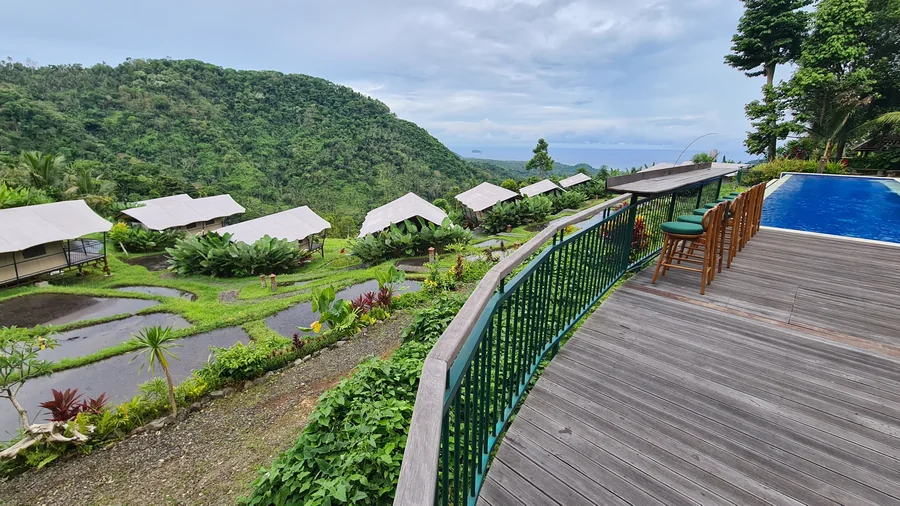 Hotelanlage in Ostbali mit Pool, grünen Hügeln und Meerblick